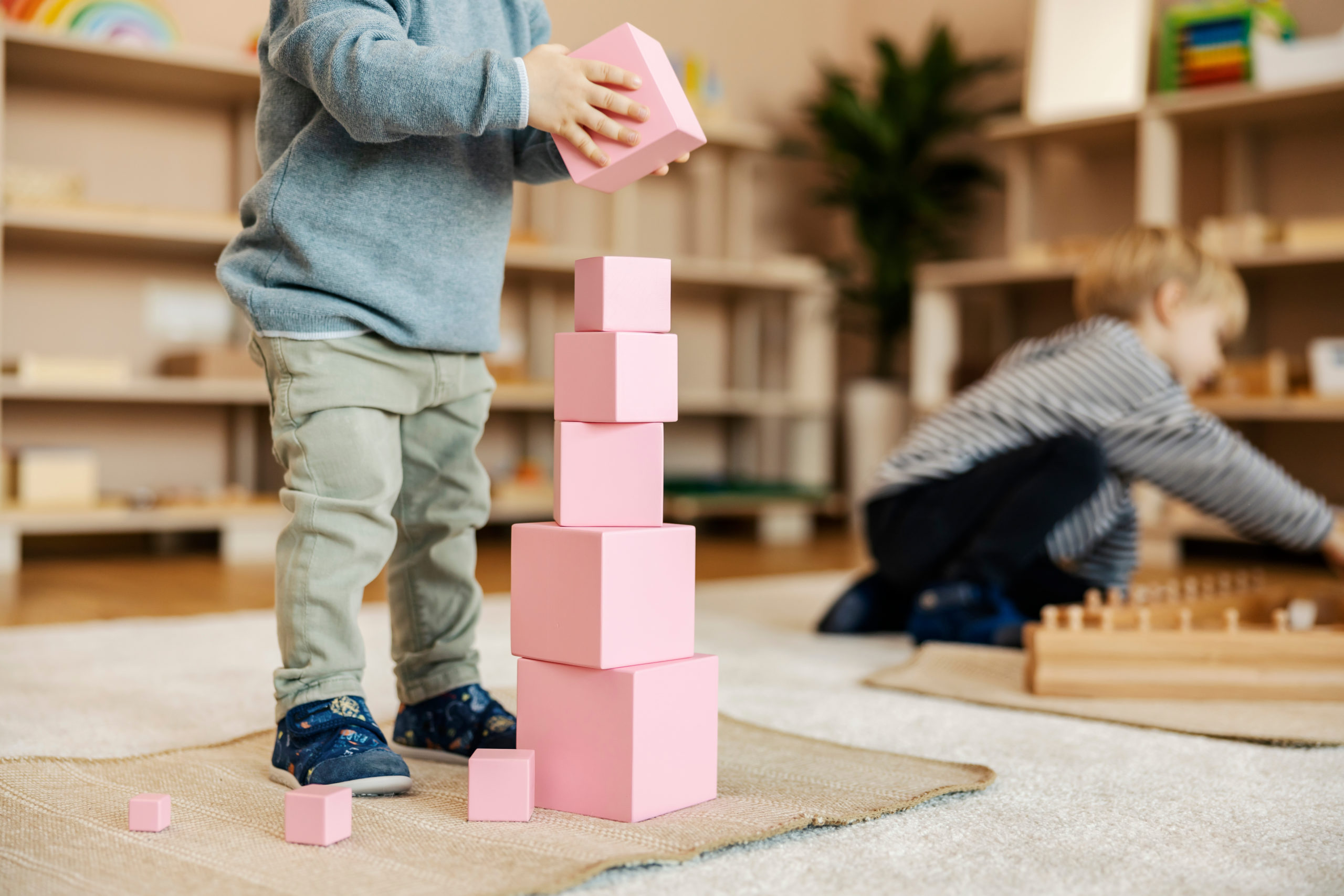 Cropped picture of a toddler building a tower with wooden blocks